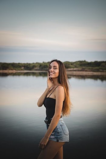 woman in black spaghetti strap top and blue denim shorts