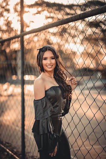 Woman In Black Standing and Holding Chain Link Fence