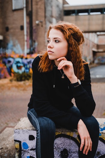 Woman in Black Sweater Sitting Outdoors