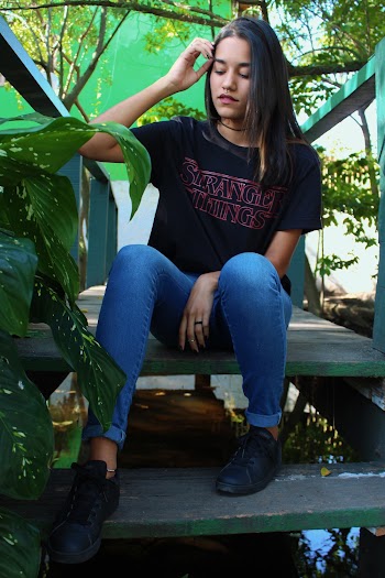 Woman in Black T-shirt Sitting on Bridge