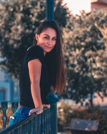 Woman in Black T-shirt Standing Near Green Trees