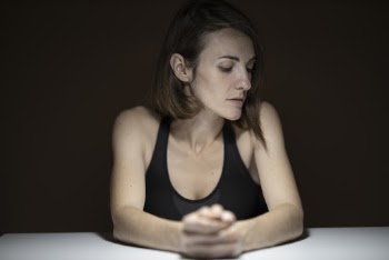 Woman in Black Tank Top Resting Her Hands on The Table
