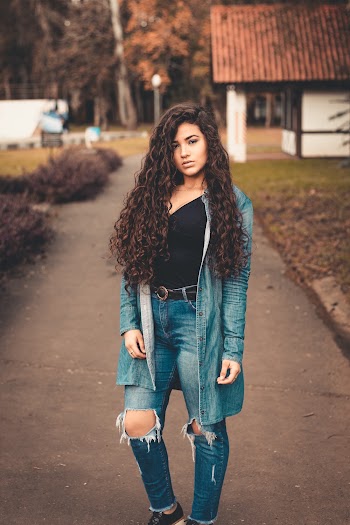 Woman in Black Top and Blue Denim Cardigan Standing Outdoors