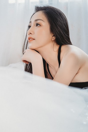 Woman in Black Top Lying on Bed