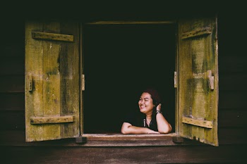 Woman in Black Top Sitting in Front of Opened 2-door Panel Window