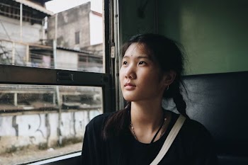 woman in black top sitting in vehicle near window