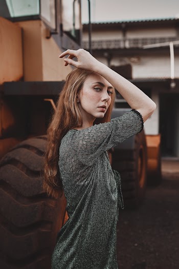 Woman in Black Top Standing Beside Heavy Equipment