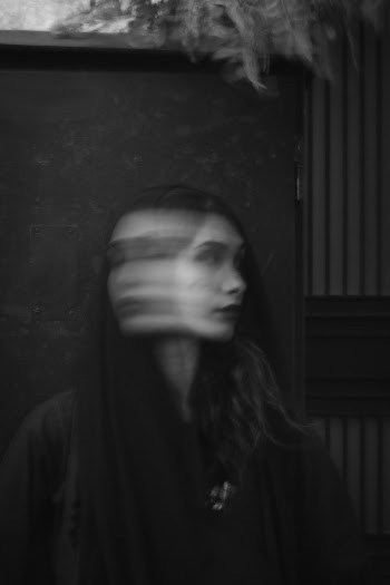Woman in Black Top Standing Beside Wall