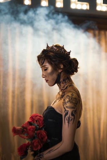 woman in black tube dress holding bouquet of flowers