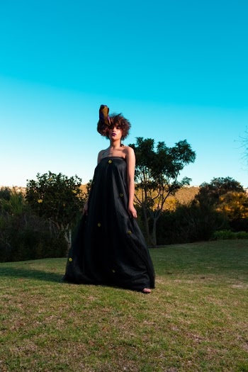Woman In Black Tube Dress Standing On Green Grass Field