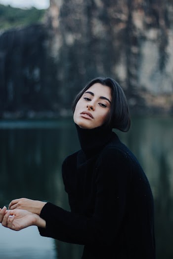 Woman in Black Turtleneck Sweater Standing Near Calm Body of Water