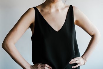 woman in black V-neck sleeveless top with hands on her waist