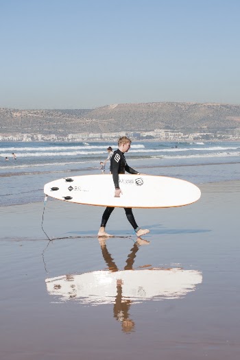 Woman in Black Wet Suit Carrying   White Surfboard on Beach