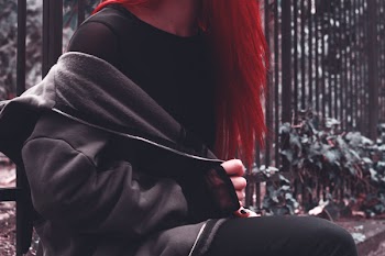Woman in Black Zip-up Jacket Near Green Leaf Plant