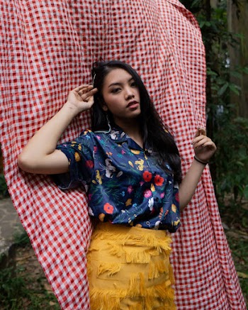 Woman in Blue and Multicolored Floral Button-up Collared Short-sleeved Shirt and Yellow Fringe Skirt