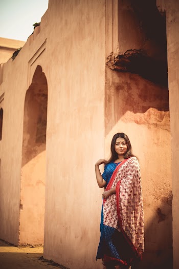 Woman in Blue and Red Dress Standing Beside Building
