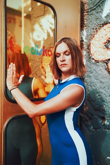 Woman in Blue and White  Leaning Near Door