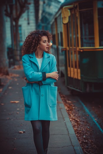 Woman in Blue Coat Standing on Grey Concrete Surface