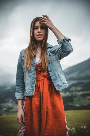 Woman in Blue Denim Button-up Jacket Behind Green Grass Field