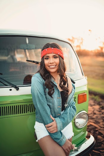 Woman In Blue Denim Button-up Jacket Leaning In Front Of A Vehicle