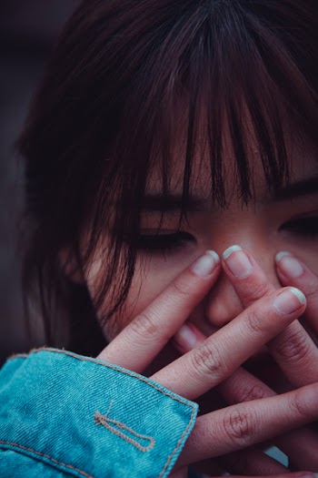 Woman in Blue Denim Jacket With Hands on Her Face