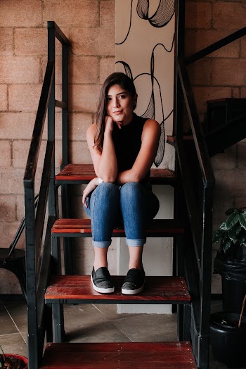 Woman in Blue Denim Jeans Sitting on Brown Stair