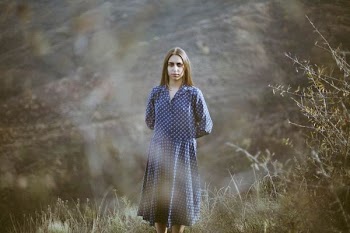 woman in blue dress standing on green grass