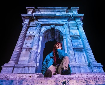 Woman in Blue Jacket Sitting Beside Arco di Traiano