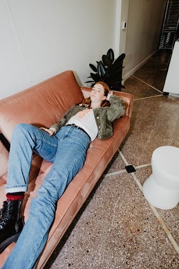 woman in blue jeans laying on couch
