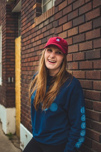 Woman In Blue Long-sleeved Shirt Leaning On Wall