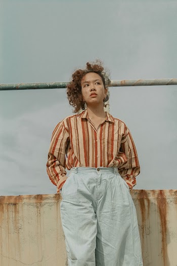 Woman in Blue Pants and Colorful Striped Shirt
