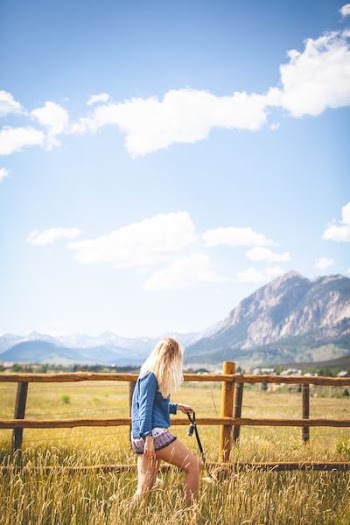 woman in blue sweatshirt walking on field