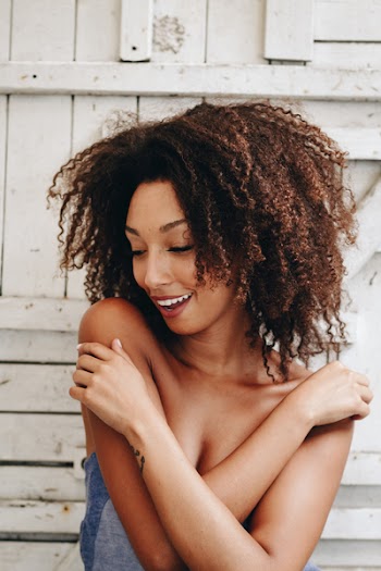 Woman In Blue Top Against Wall