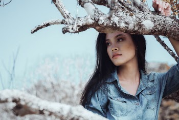 Woman In Blue Top Beside Tree