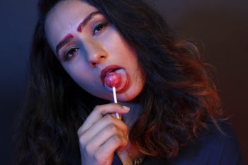 Woman in Blue Top Licking Pink Lollipop Candy Low-light Photography