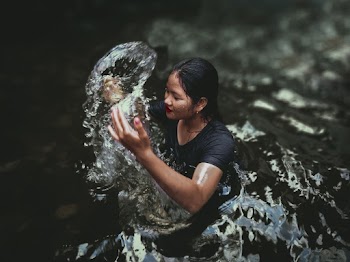 Woman In Body Of Water Raising Both Hands