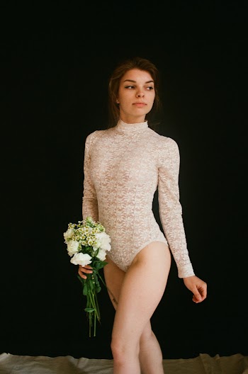Woman in Body Suit Carrying Flowers