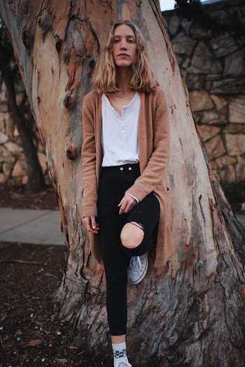 Woman in Brown Cardigan Leaning on a Tree
