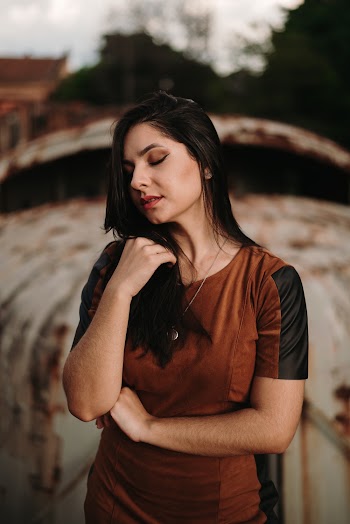 Woman in Brown Dress Standing While Holding Her Hair