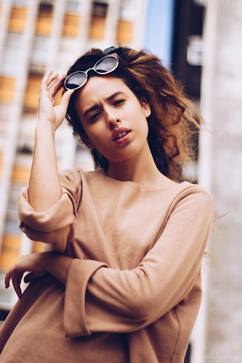 Woman in Brown Elbow-sleeved Shirt Holding Sunglasses