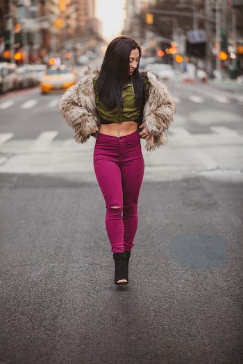 Woman in Brown Fur Jacket and Purple Leggings Walking on the Street