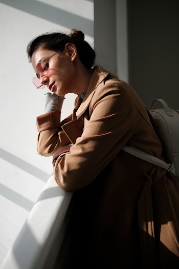 Woman in Brown Jacket and White Leather Backpack