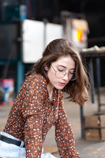 Woman in Brown Long-sleeved Shirt Sitting on Sidewalk