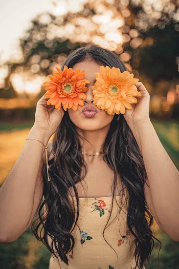 Woman in Brown Top Holding Orange Petaled Flowers