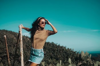 woman in brown turtle-neck T-shirt holding brown bamboo stick