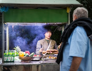 Woman in Bucket Hat In A Food Stall