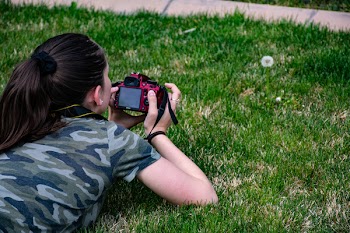 Woman in Camouflage T-shirt Holding Dslr Camera