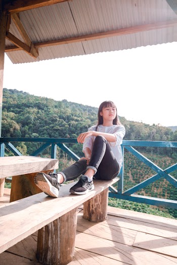 Woman in Casual Wear Sitting on Wooden Bench