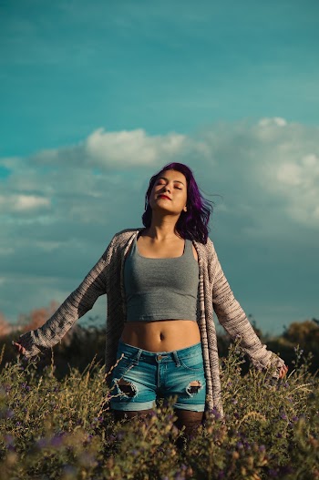 Woman in Crop Top and Short  Standing on Green Grass Field 