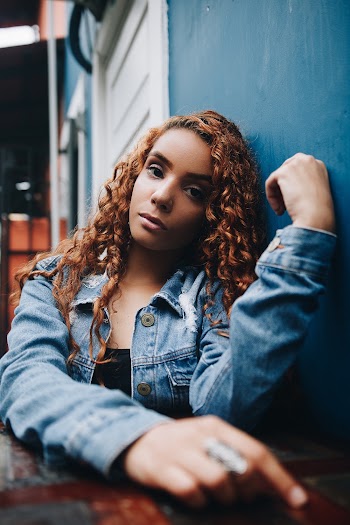 Woman in Denim Jacket Leaning on Wall